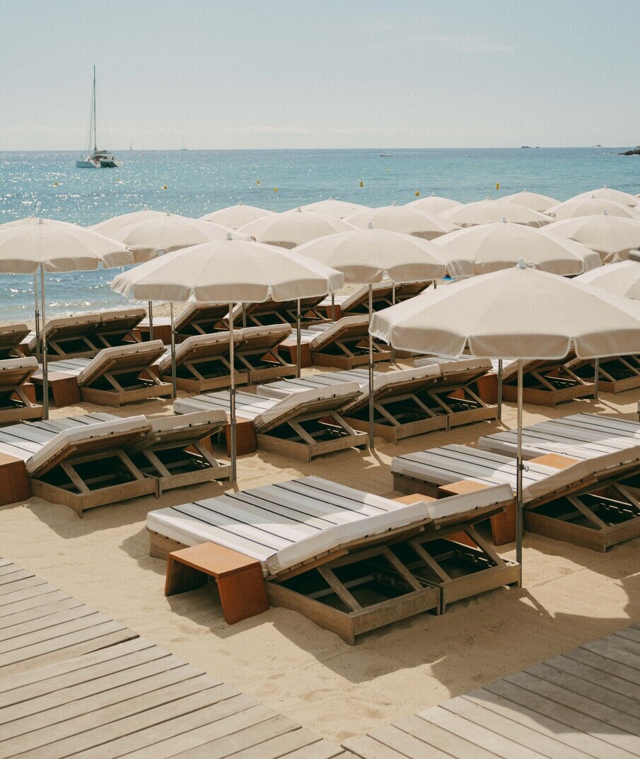 Plage de Pampelonne – rangées de transats et parasols blancs face à la Méditerranée